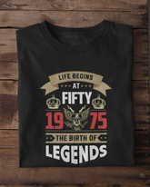 Black t-shirt with a design on a wooden surface with white sneakers in the foreground.